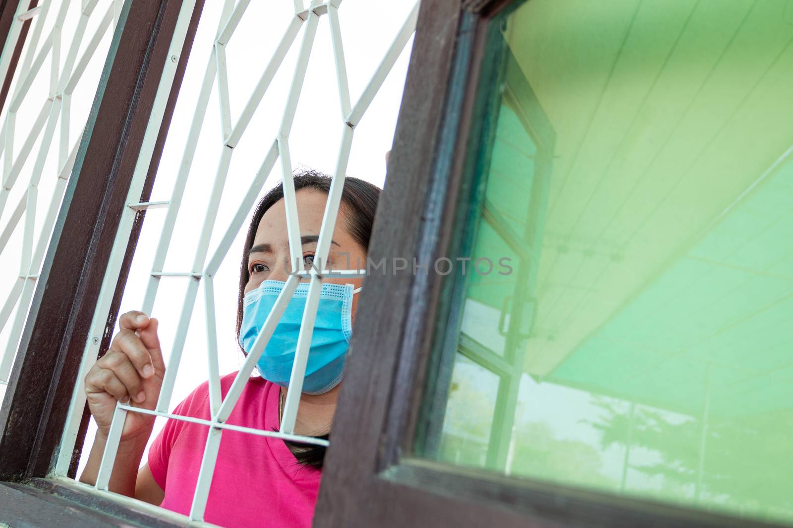 Corona virus (COVID-19), During detention at home Masked woman Feeling sad and lonely alone in the house Sometimes she uses her phone to make video calls to friends.