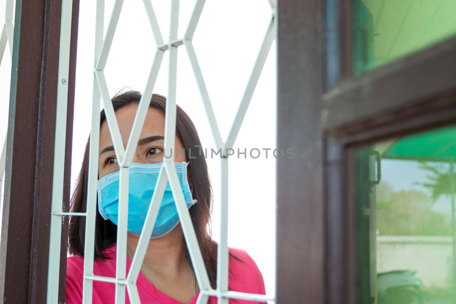Corona virus (COVID-19), During detention at home Masked woman Feeling sad and lonely alone in the house Sometimes she uses her phone to make video calls to friends.