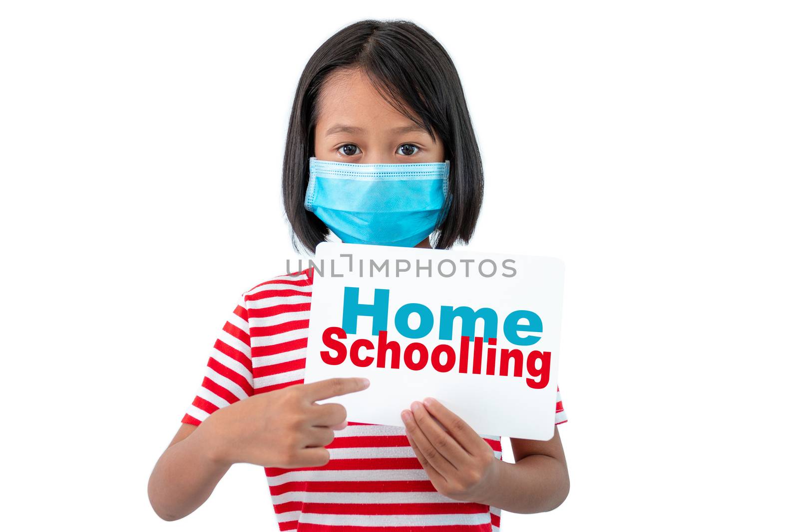Coronavirus Outbreak. Lockdown and school closures. School girl in face mask holding a sign with the words "HOME SCHOOLING"