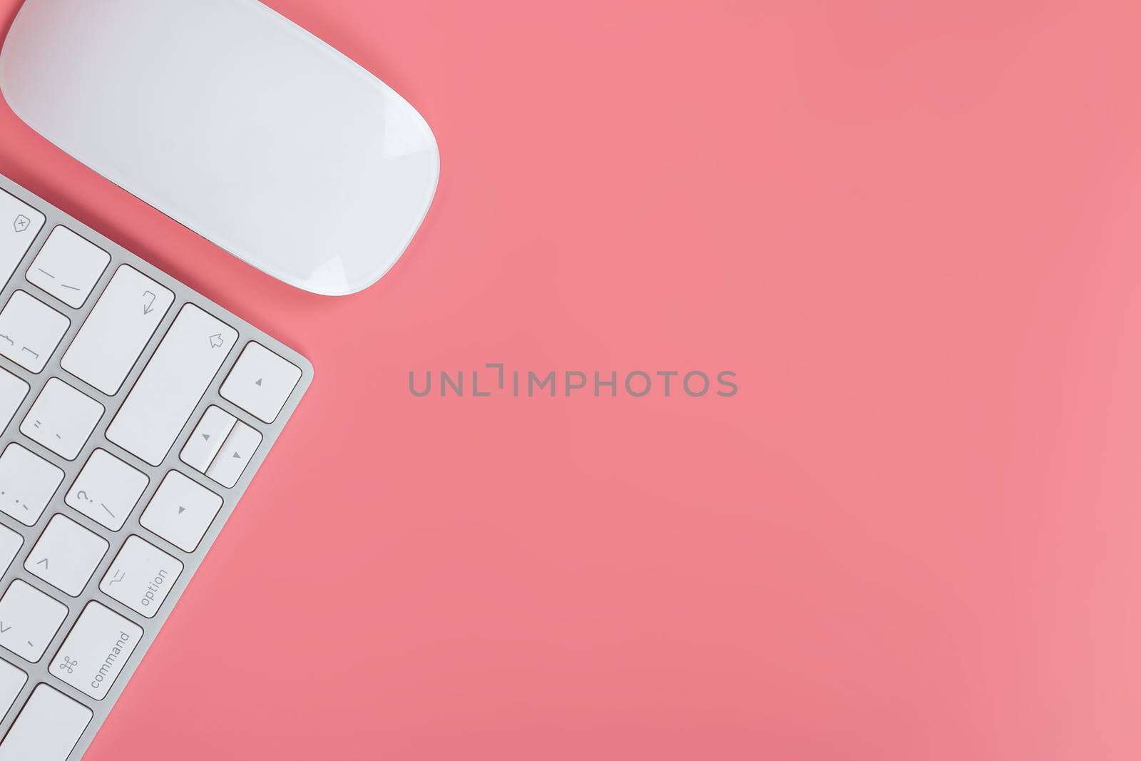 Flat lay, top view office table desk. Workspace with keyboard and mouse on pink background.