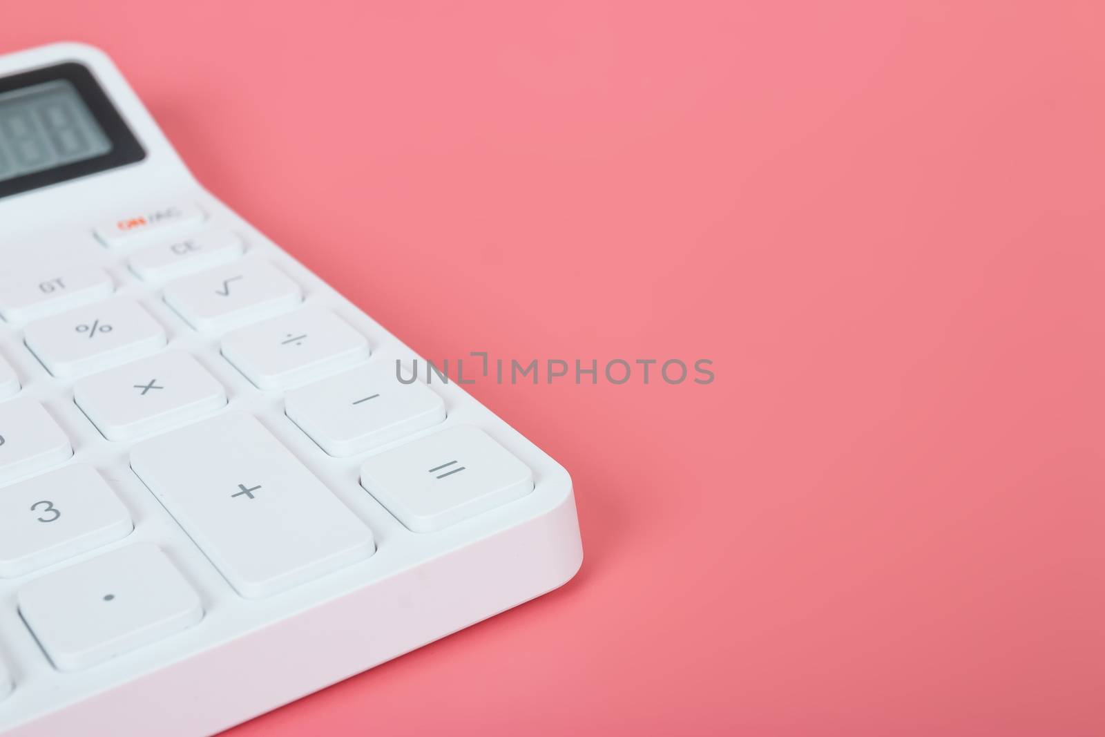 White calculator on a bright pink background, marketing and financial concepts