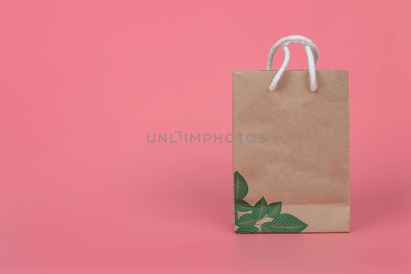 Paper bags on pastel pink backgrounds, environmental conservation concept