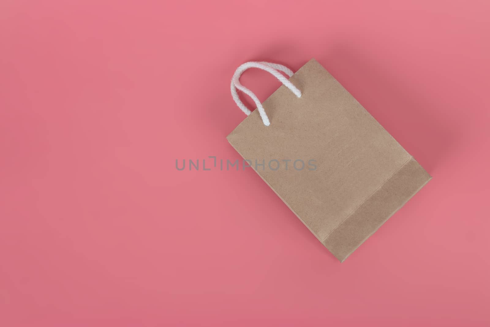 Paper bags on pastel pink backgrounds, environmental conservation concept