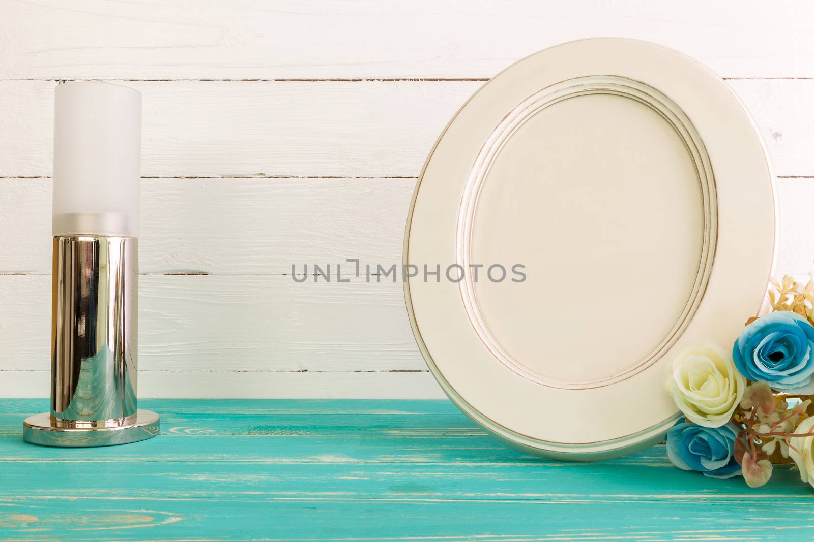 White vintage photo frame on table with decoration background.
