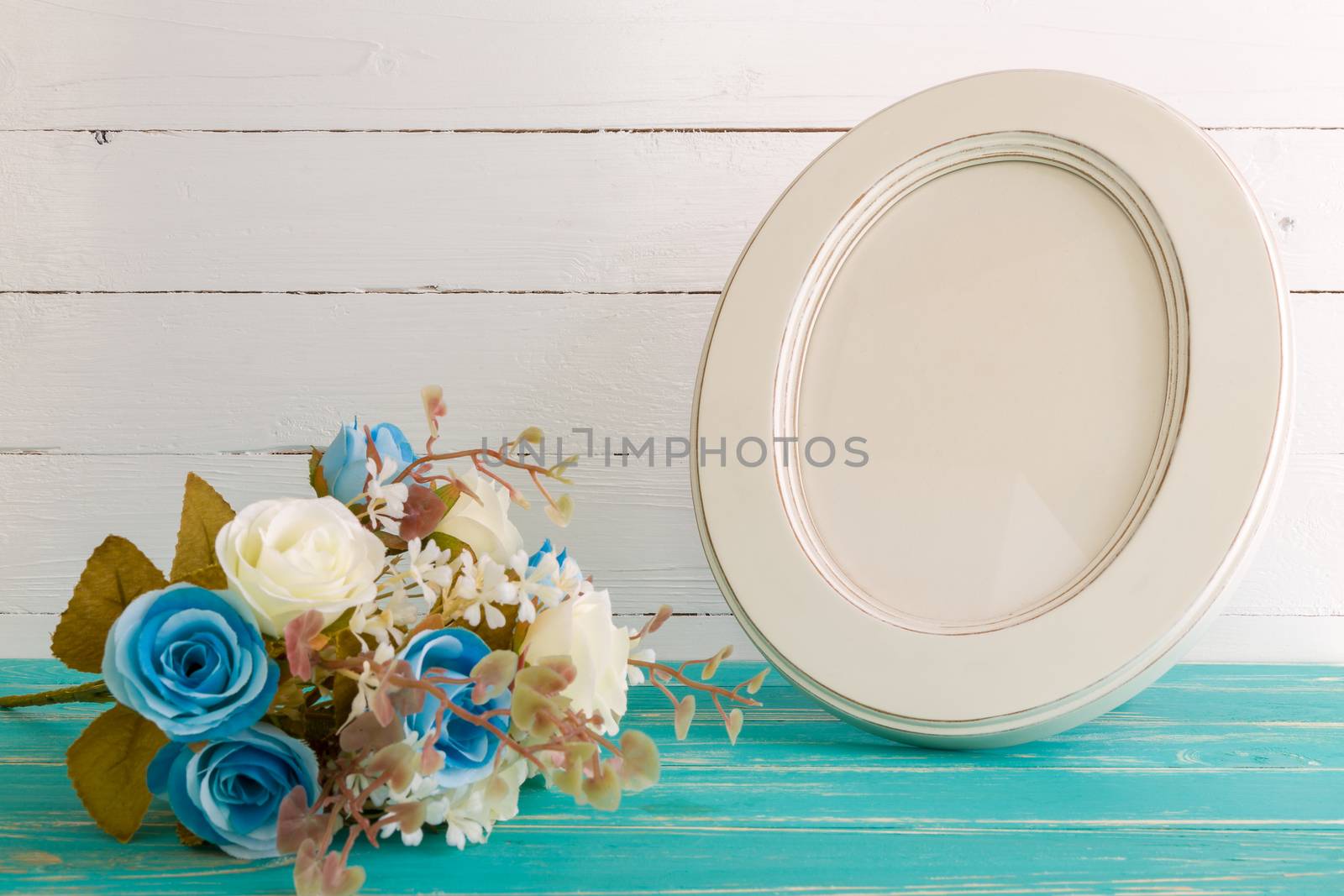 White vintage photo frame on table with decoration background.