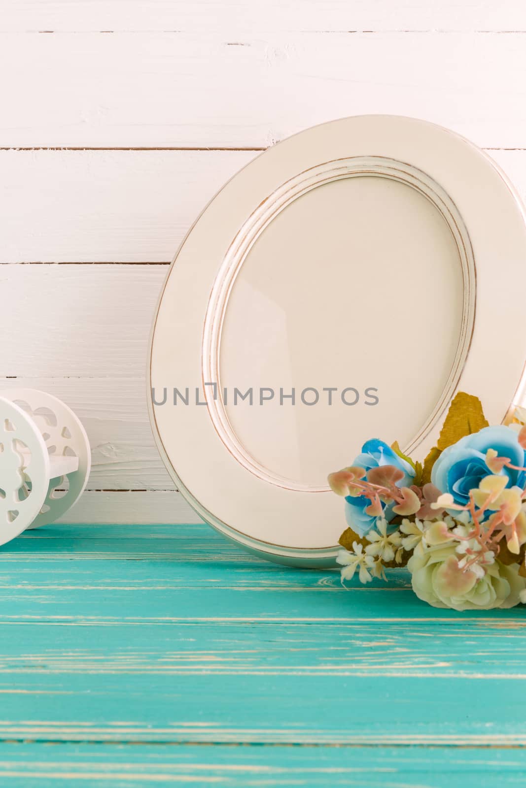 White vintage photo frame on table with decoration background.