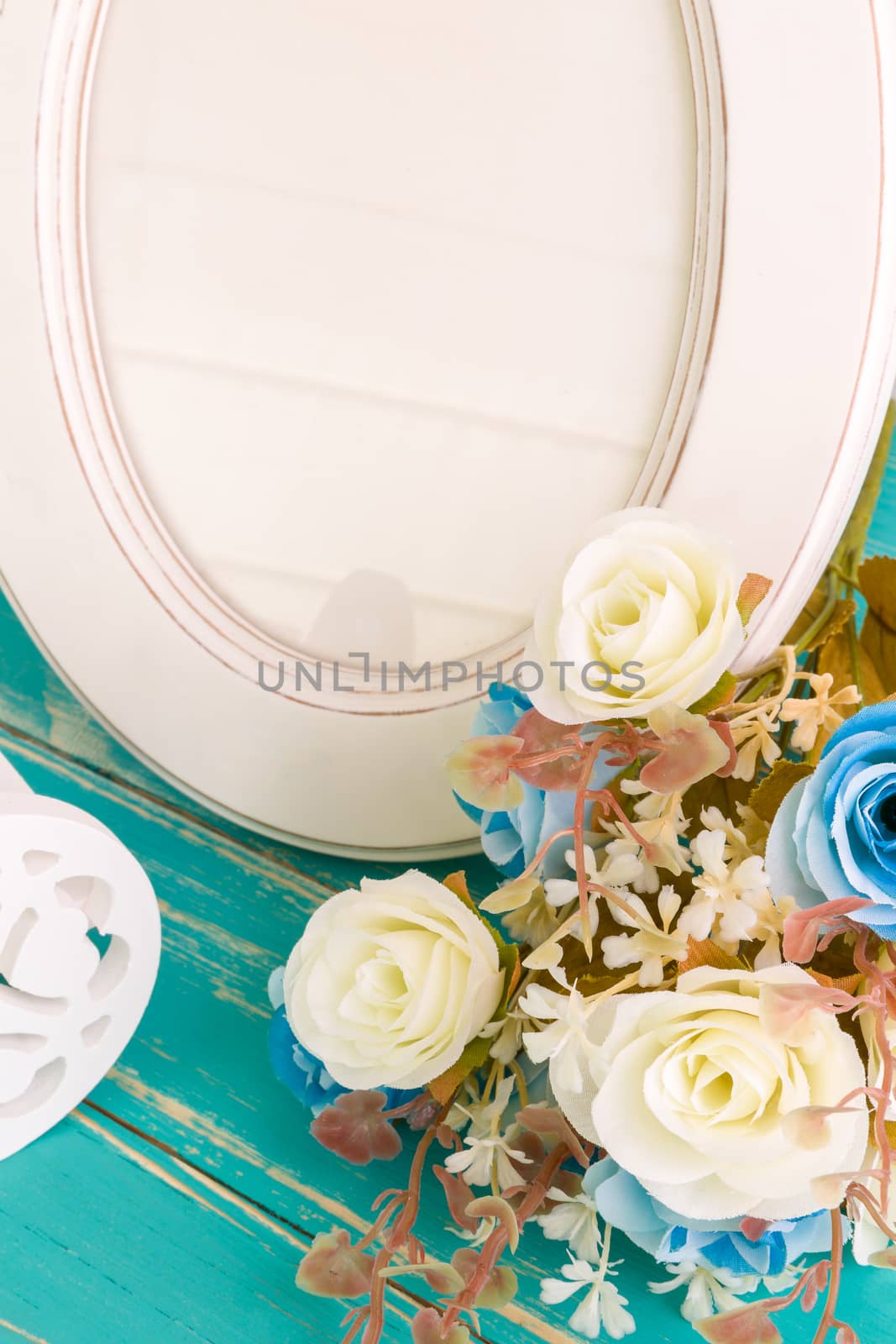 White vintage photo frame on table with decoration background.