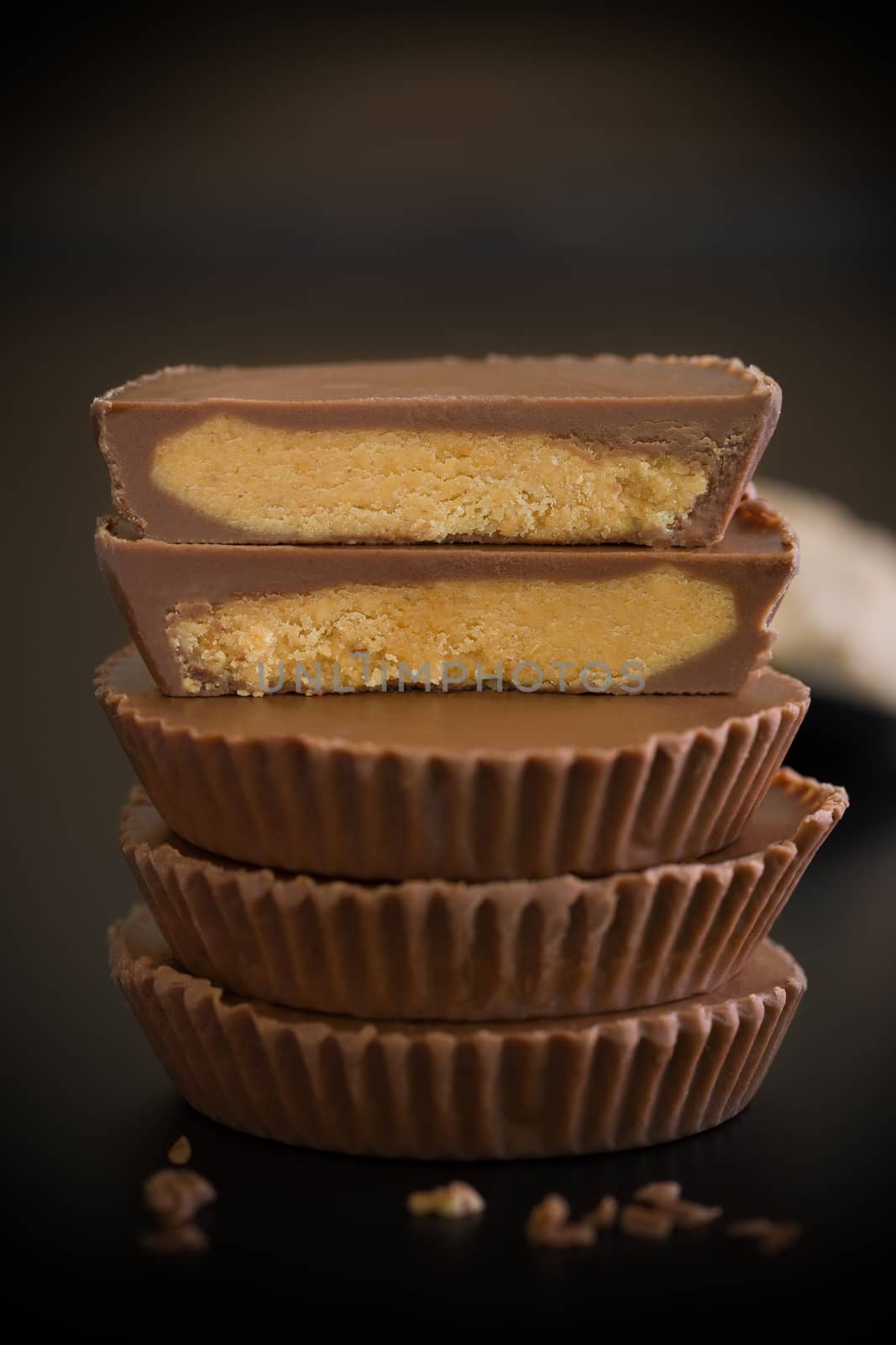 Stack of chocolate peanut butter cup on black background.