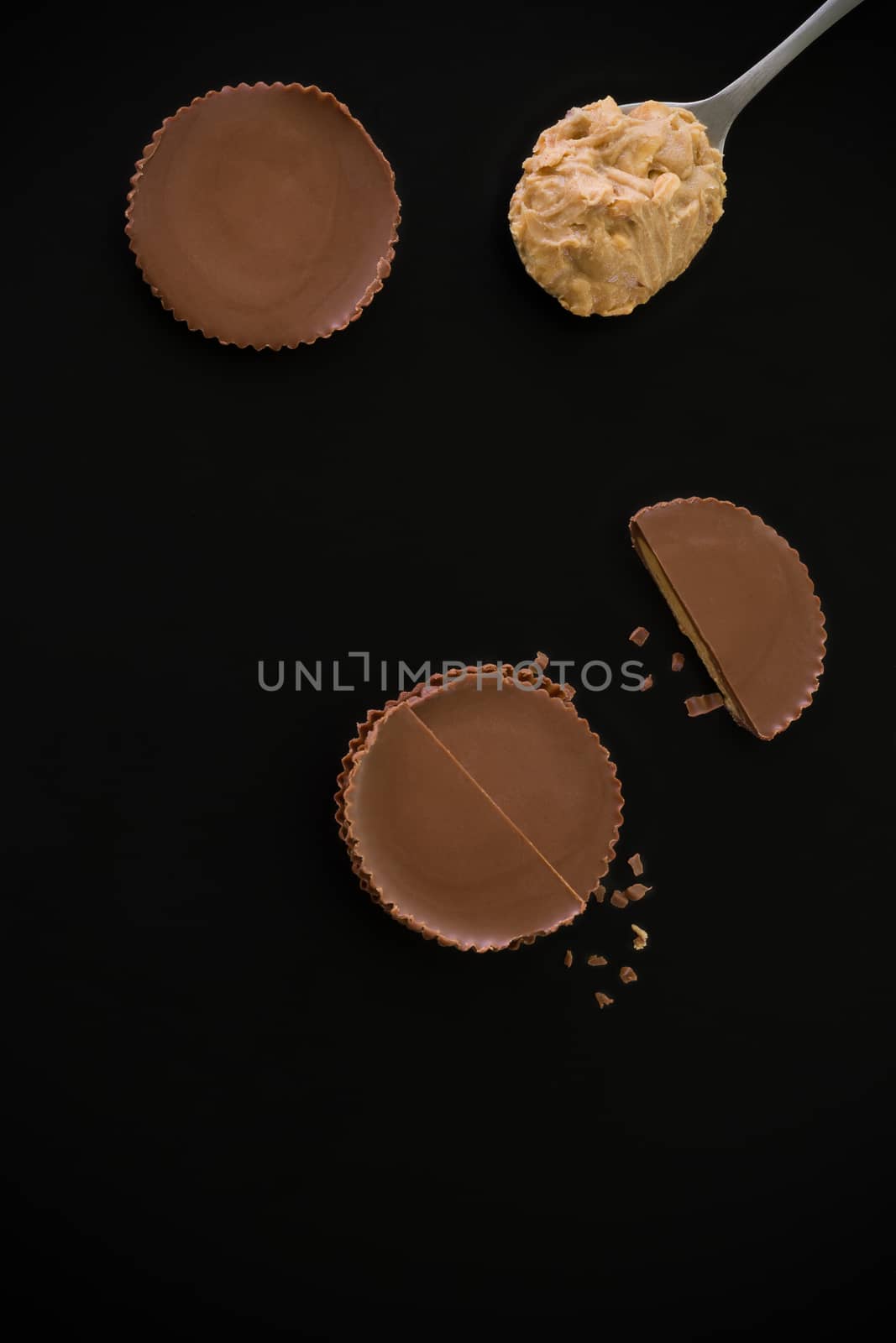 Stack of chocolate peanut butter cup on black background.