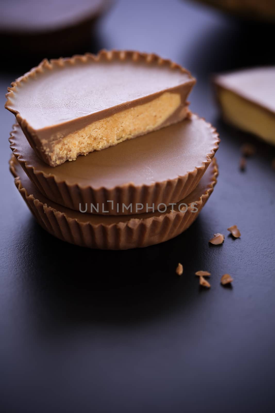 Stack of chocolate peanut butter cup on black background.