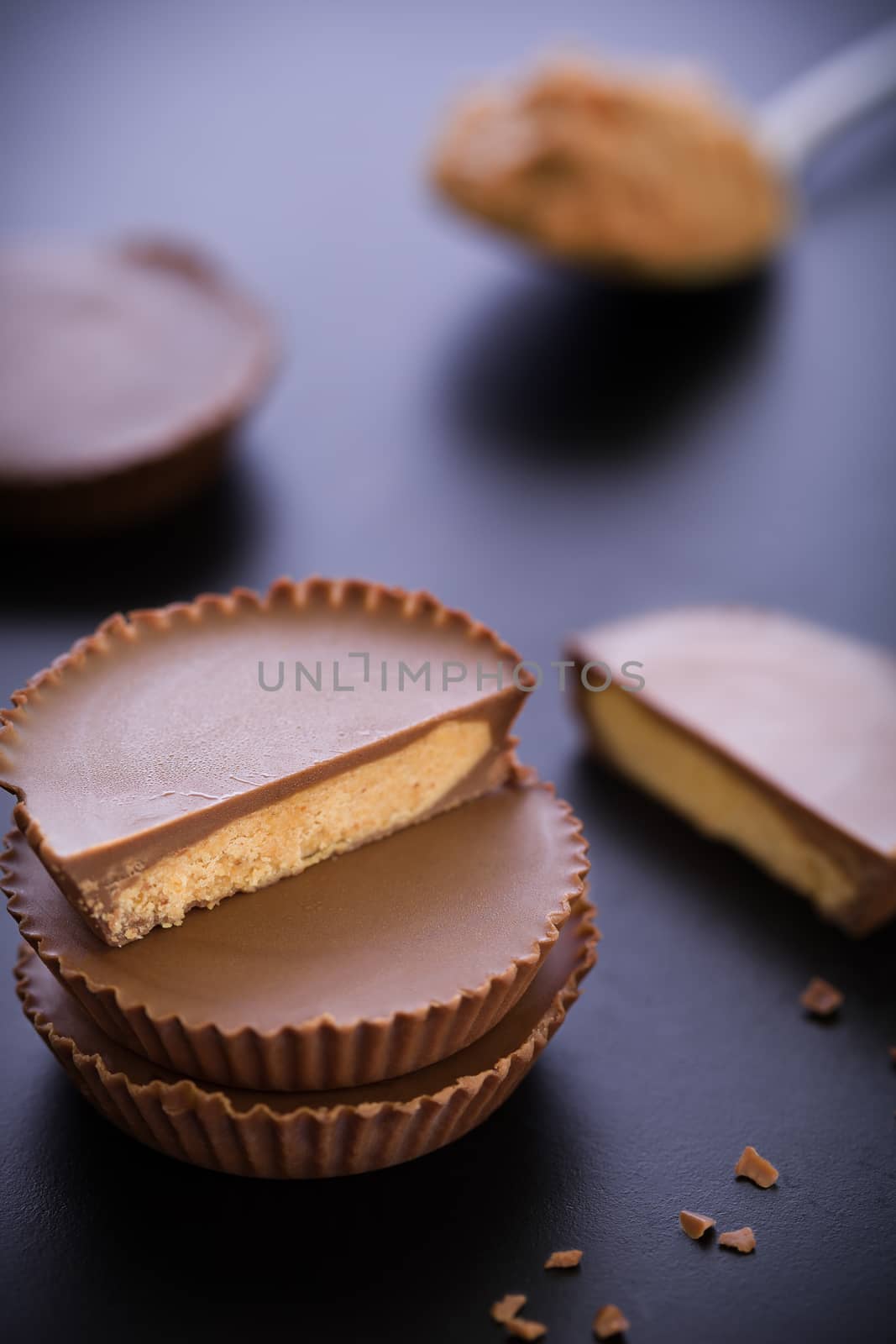 Stack of chocolate peanut butter cup on black background.