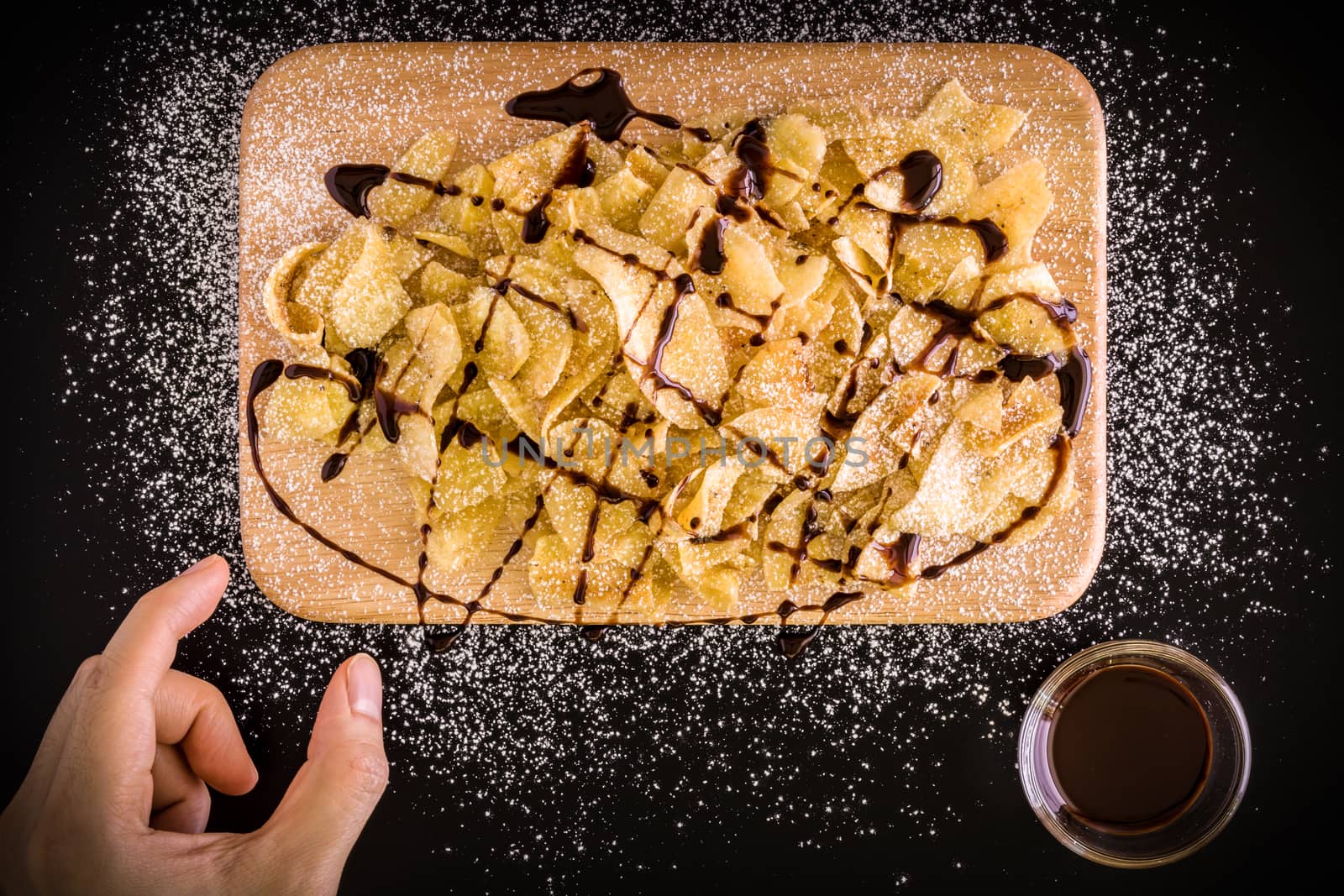 Banana chips with icing sugar and chocolate sauce.