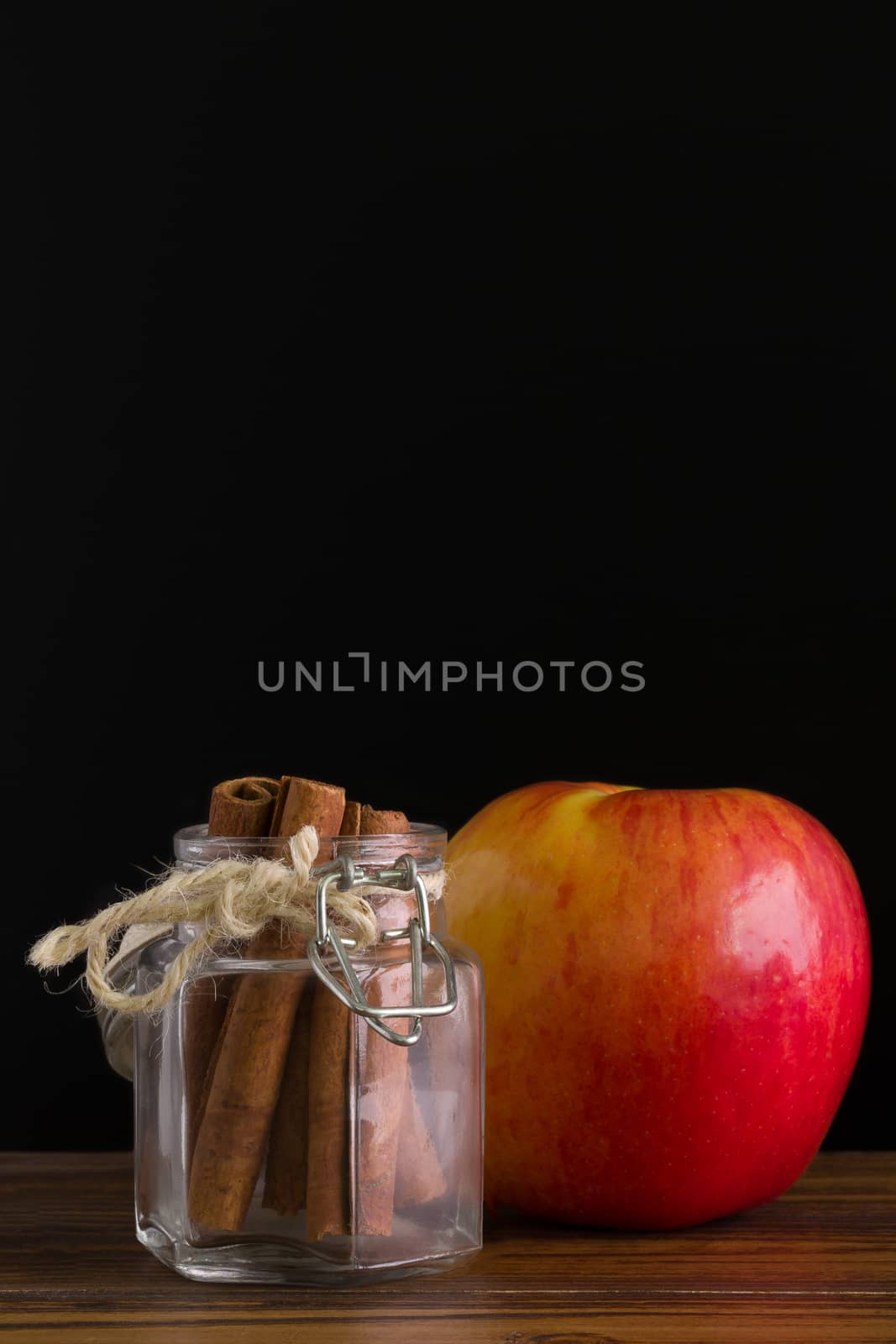 Fresh red apple with cinnamon bark stick.