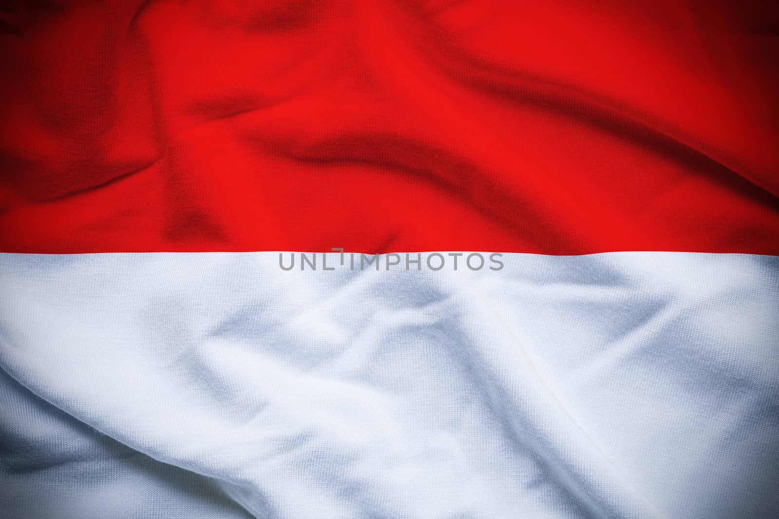 Wavy and rippled national flag of Monaco background.