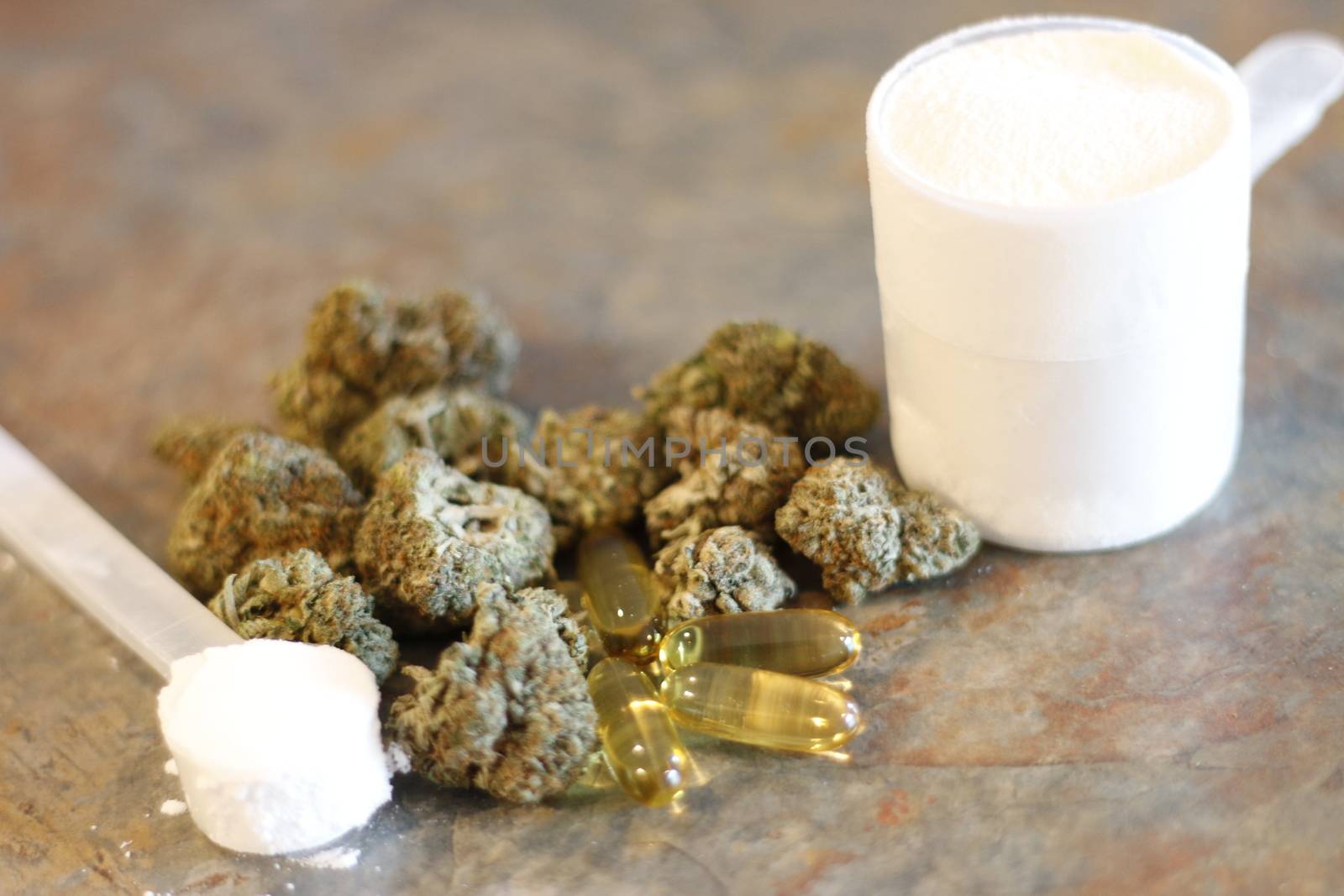 marijuana with various bodybuilding supplements on granite tabletop.