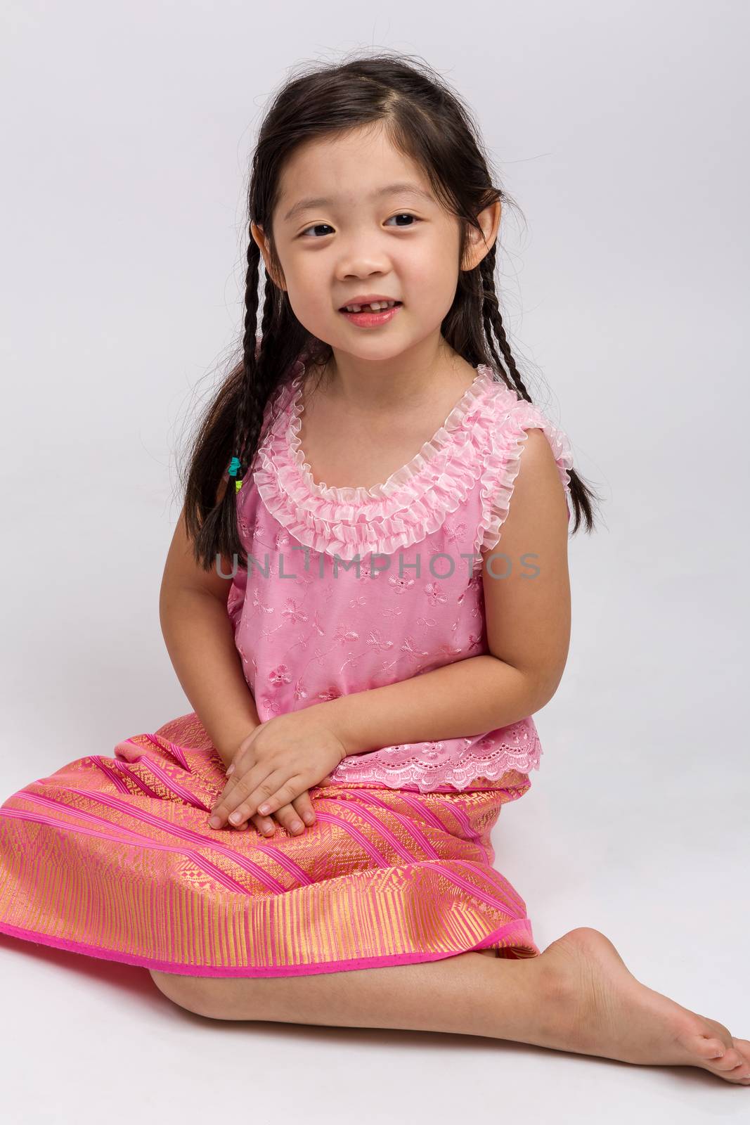 Thai child in traditional Thai costume on white background.