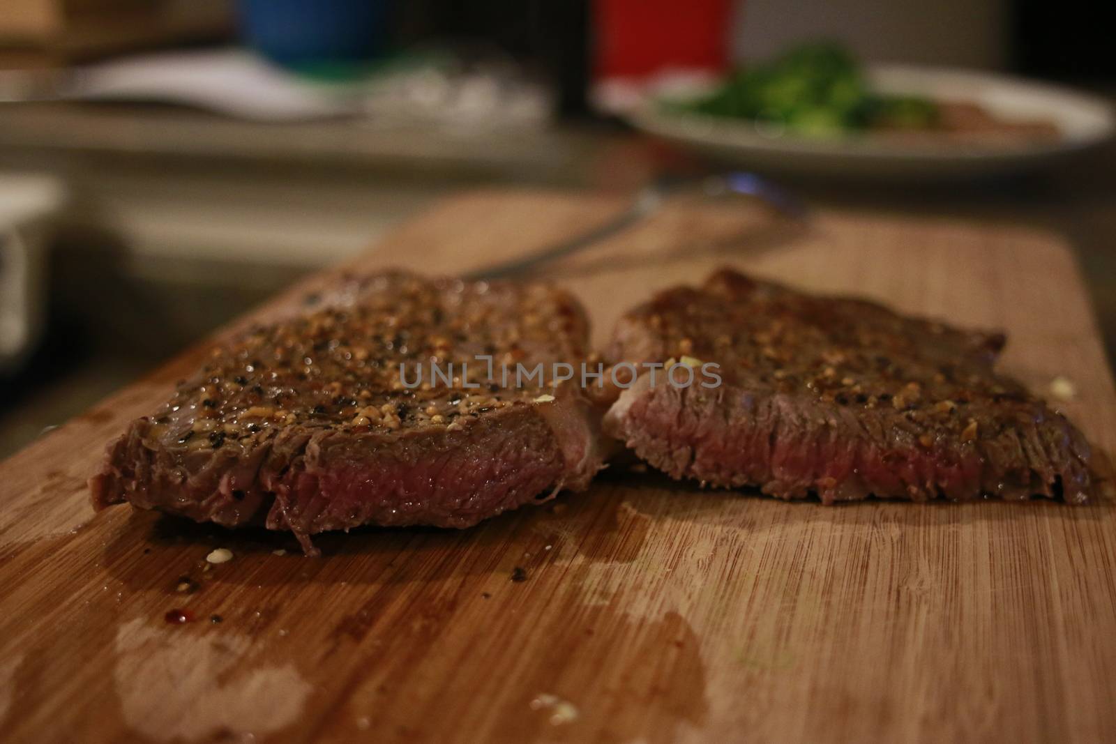 Closeup of medium rare steak with rosemary on metal table. by mynewturtle1