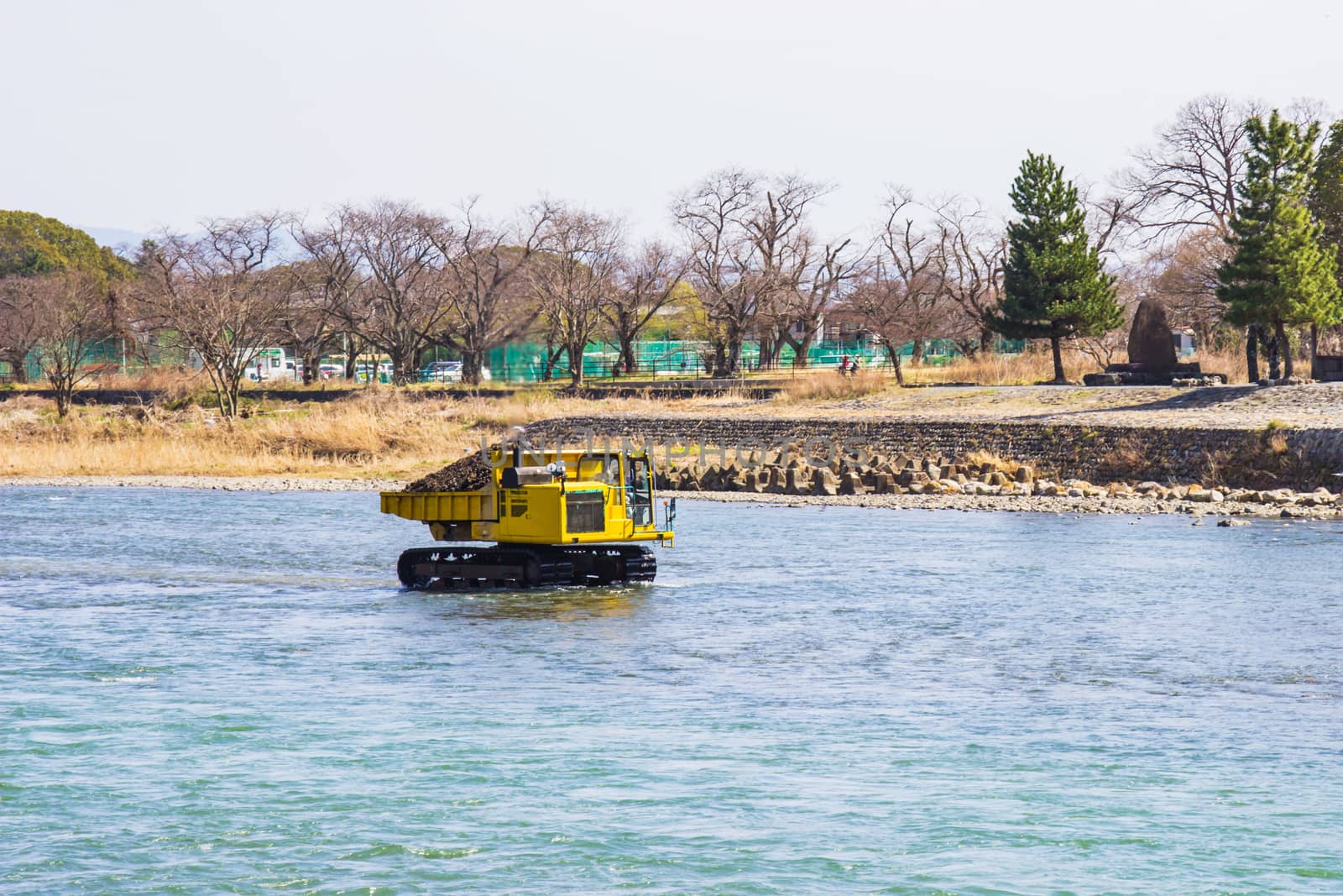 Truck and Dredging stone in river Katsura for to make water flow It's easy in Kyoto, Japan.