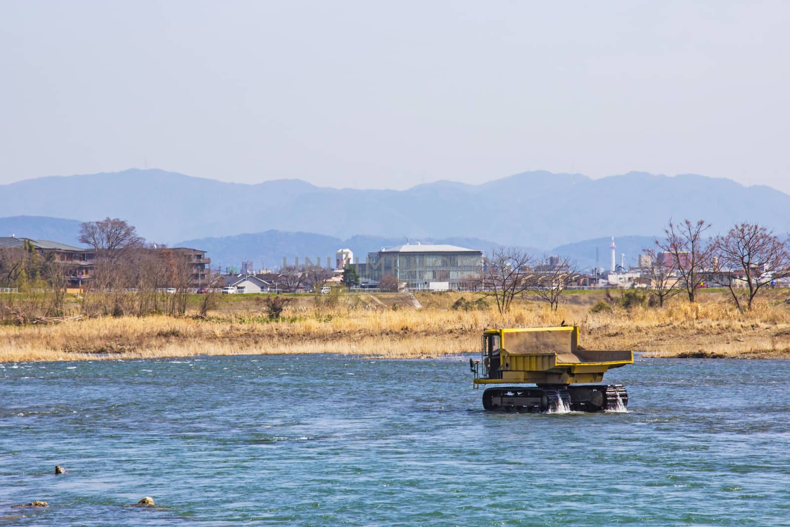 Truck and Dredging stone in river Katsura for to make water flow It's easy in Kyoto, Japan.