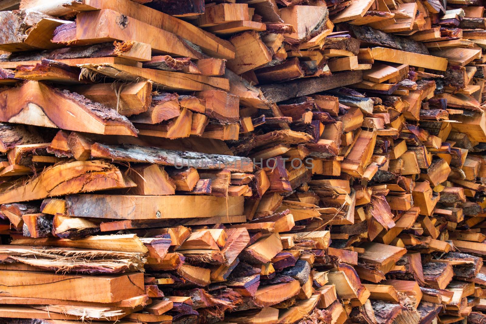 Firewood wooden logs big chopped trunks stacked pile dry for used fireplace in winter.