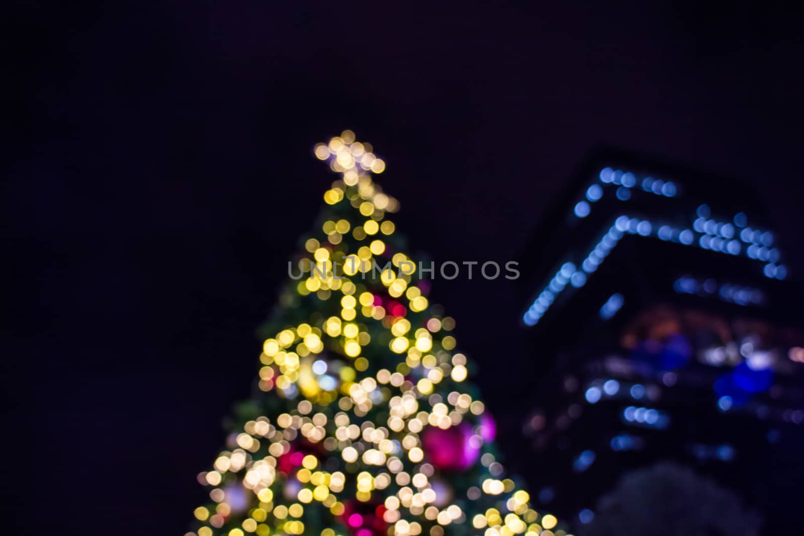 Blurred image of a Christmas tree theme of the background bokeh with golden lights glowing.