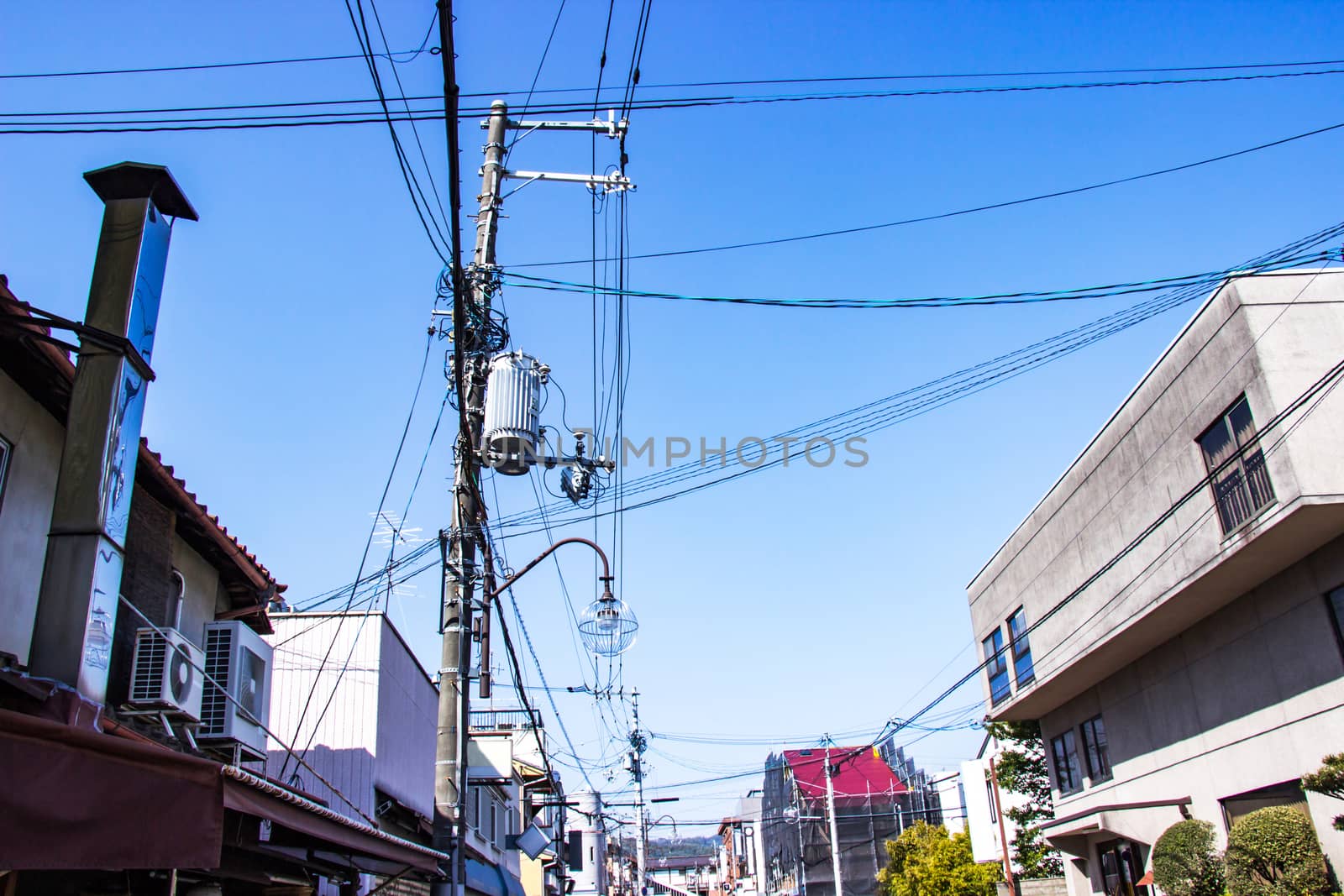 Electric pole with wires and lamp outdoor in the streets organized wiring is neat at Japan bright sky background.