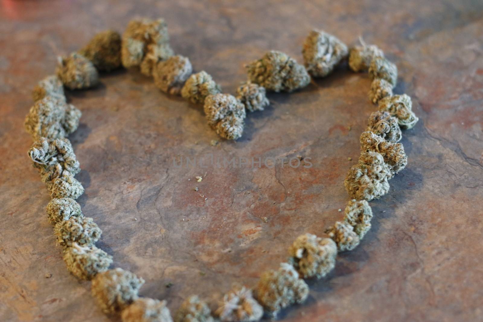 The shape of a heart made out of cannabis buds .