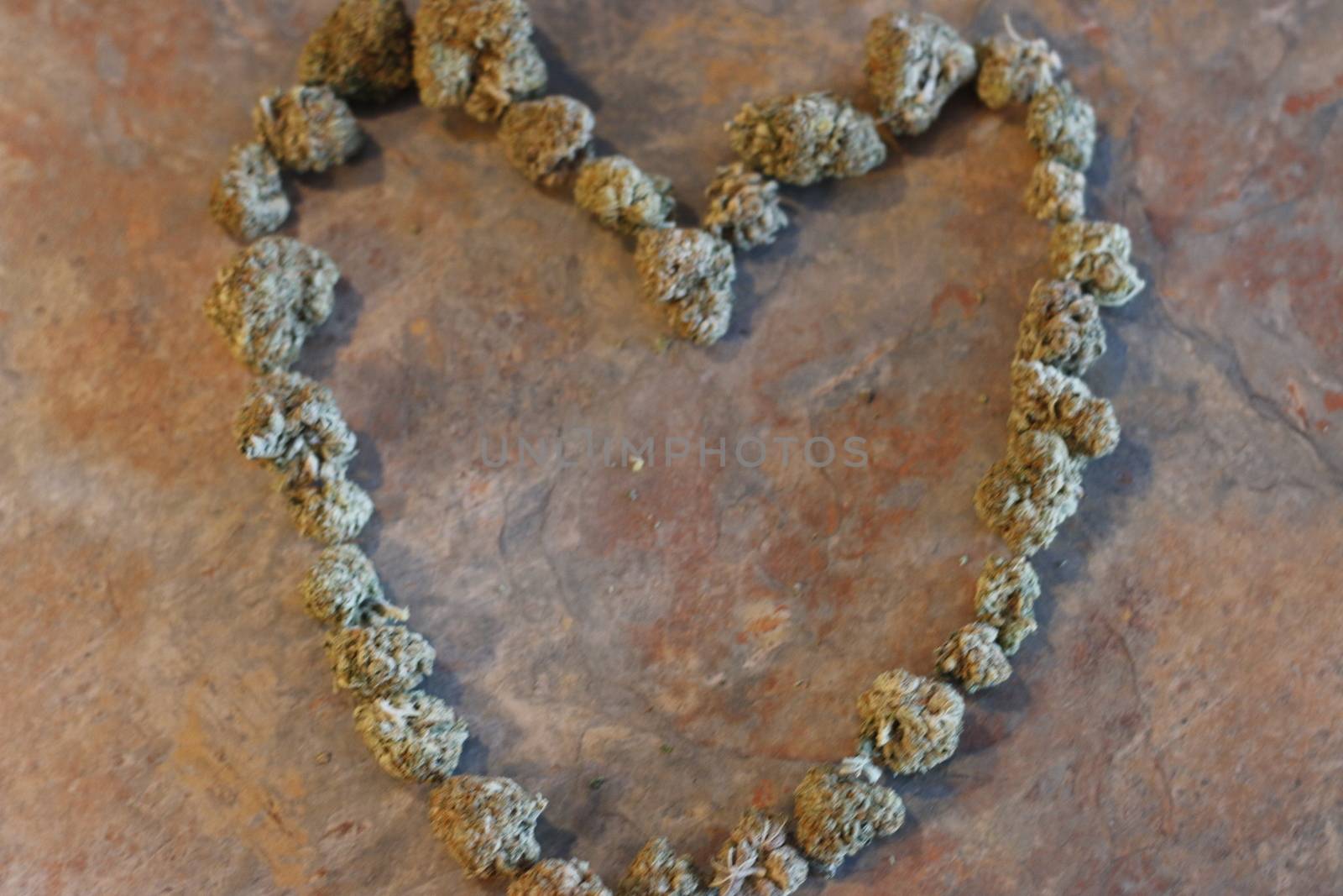 The shape of a heart made out of cannabis buds .