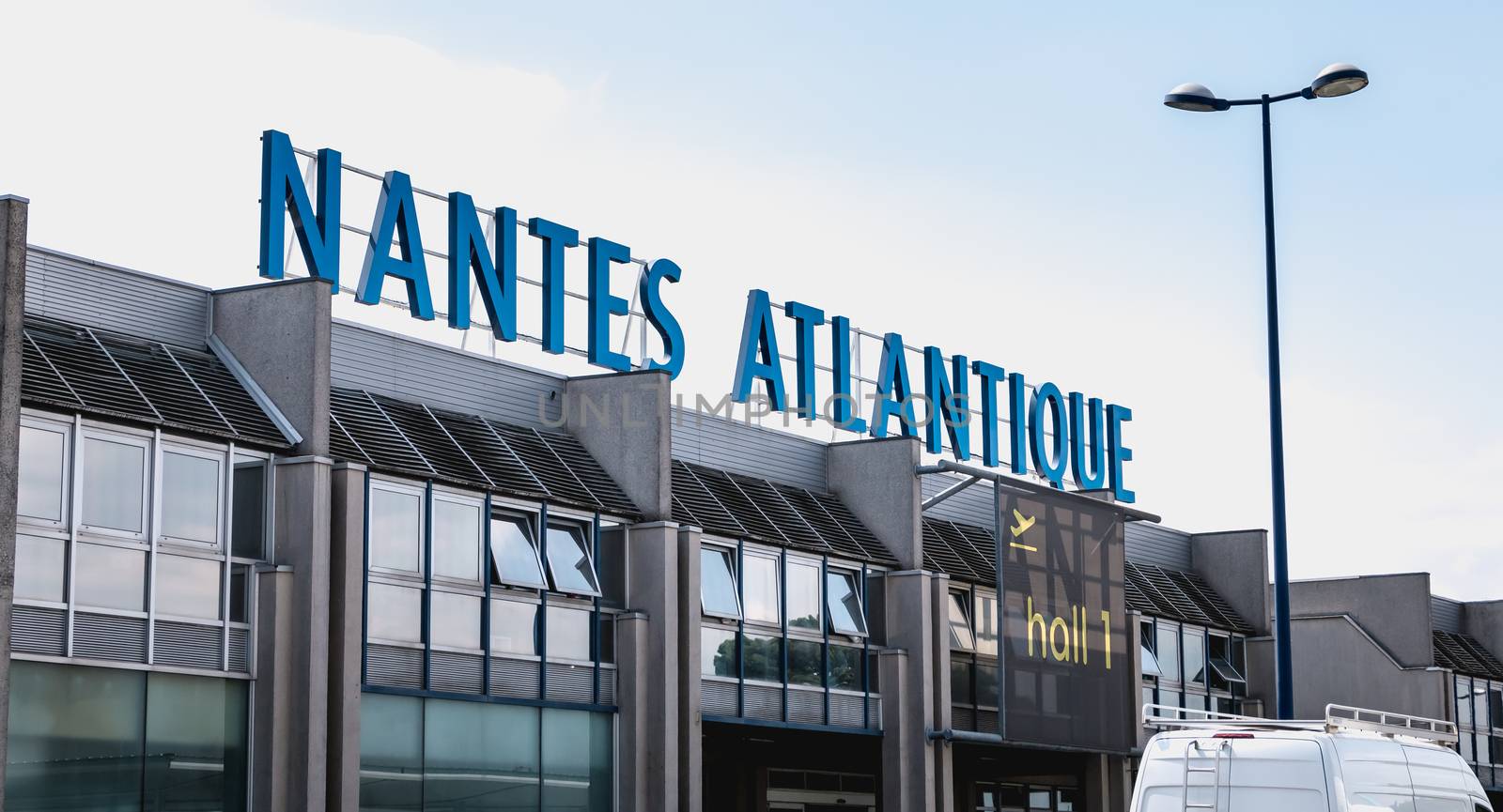 Nantes, France - August 7, 2018: view of the facade of Nantes Atlantique International Airport where travelers are walking on a summer day