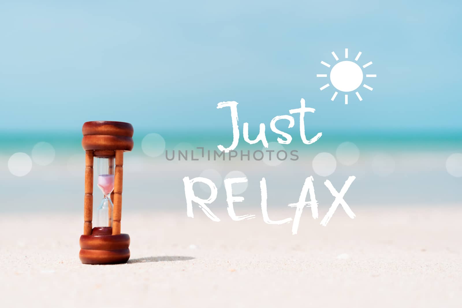 Just relax qoute with hourglass on sand and summer beach blue sky background. Time to travel tourism season concept background.