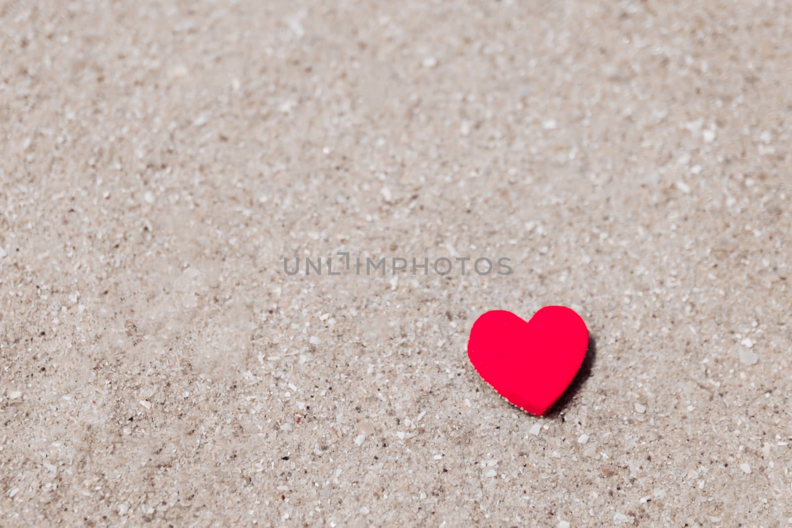 Heart shape on sand at summer beach with copy space. Valentine day concept background.