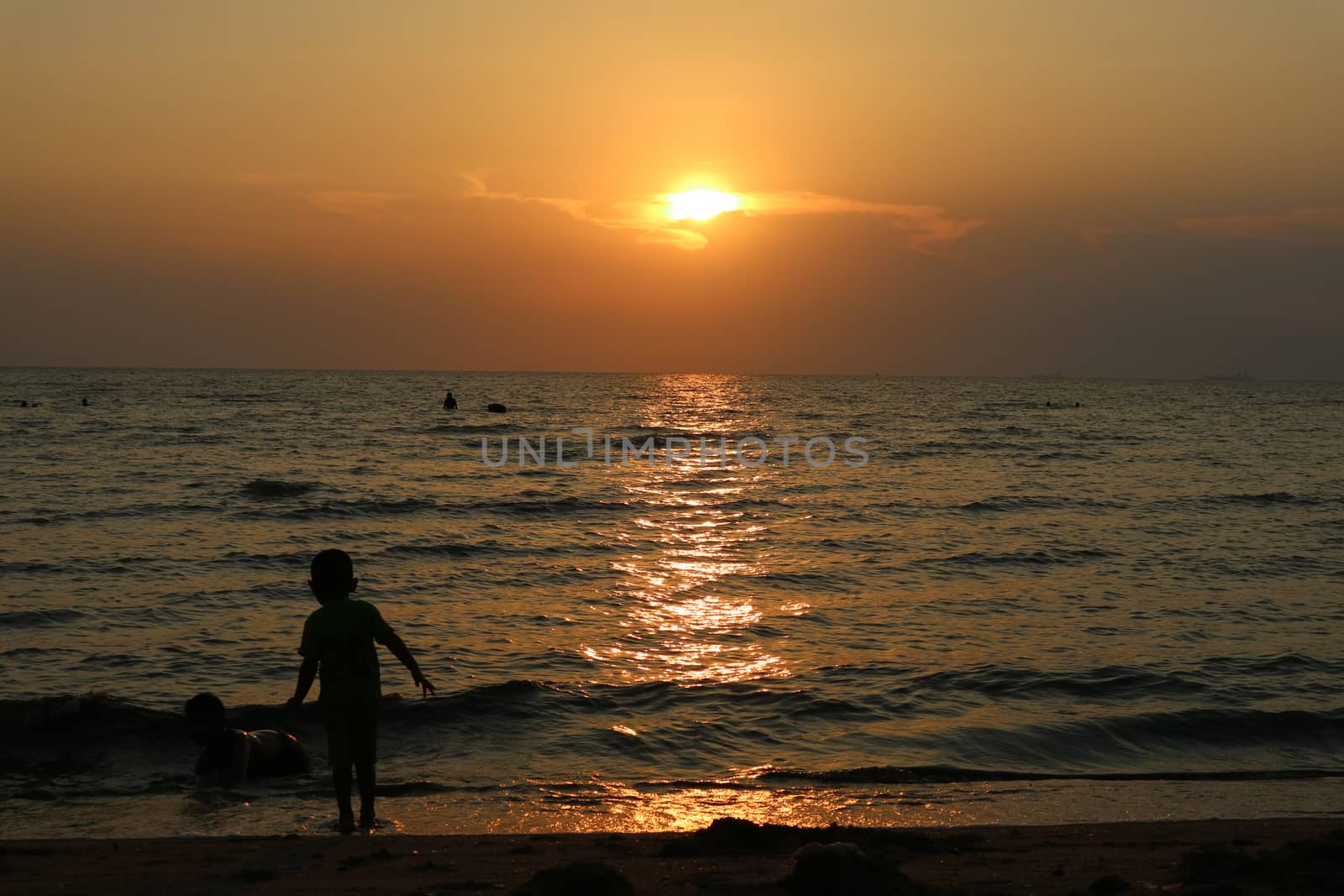 silhouette two kid  play on sea sunset, one kid stand on beach by Darkfox