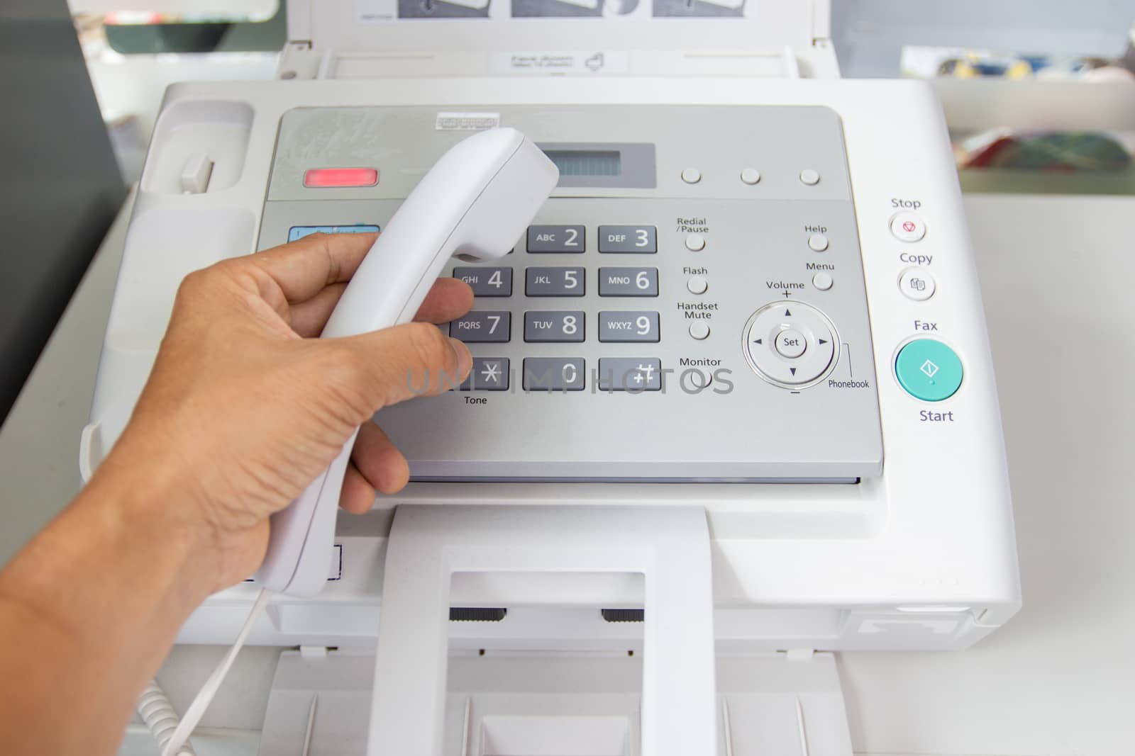 hand man are using a fax machine in the office Business concept by piyaphun