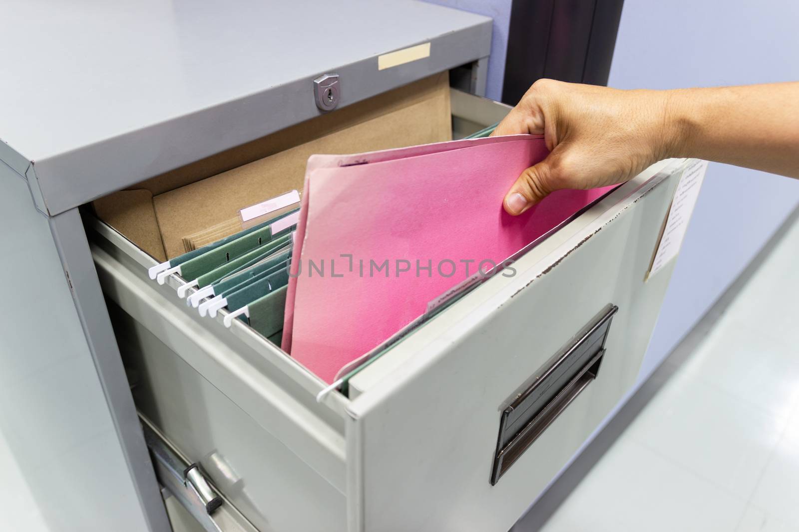 Hand of Man Search files document in a file cabinet in work office, concept business office life.