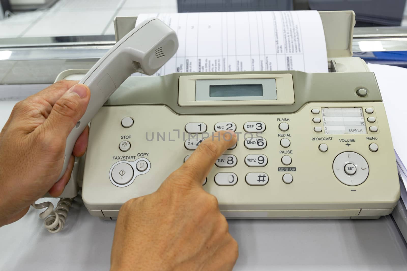 Men are using a fax machine in the office. business concept