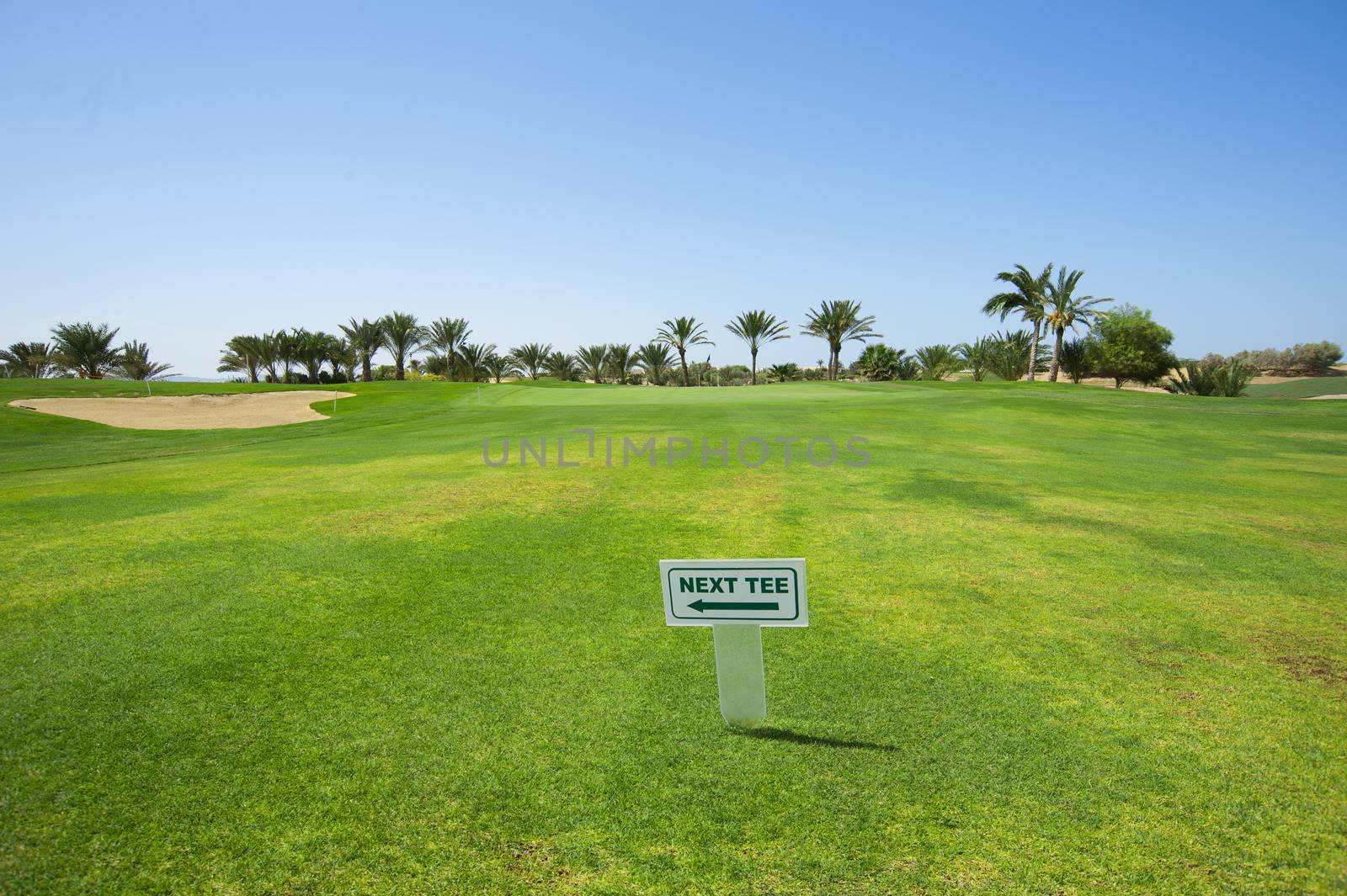 Sign on the fairway of a golf course indicating way to next hole