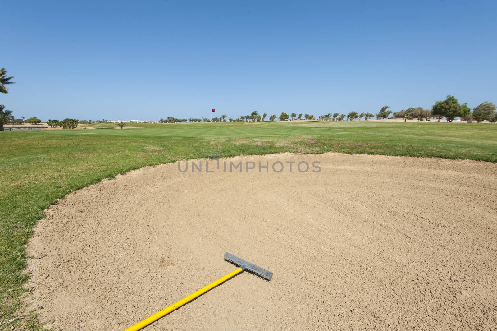 Bunker sand trap on a golf course with green in the distance