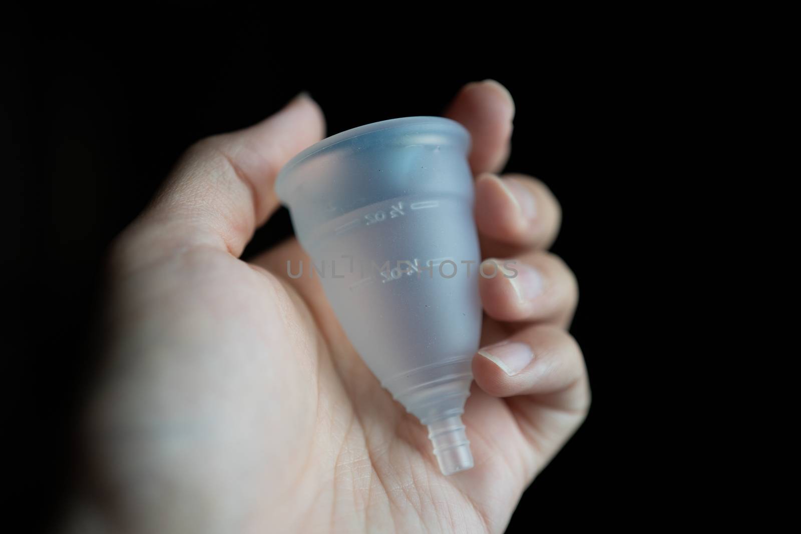 Hand holding menstrual silicone cup.