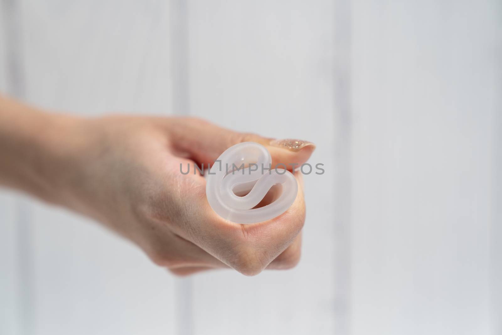 Woman hands folding a menstrual silicone cup.