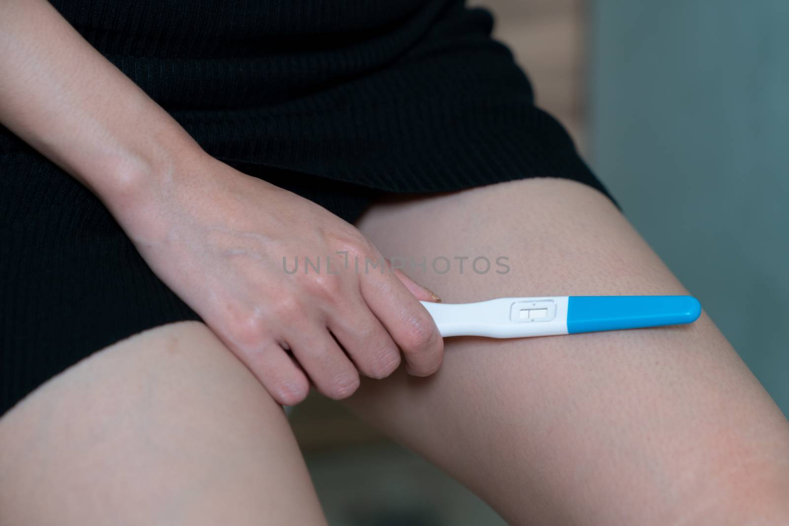Female hand holding negative pregnancy test, with not pregnant r by sirawit99