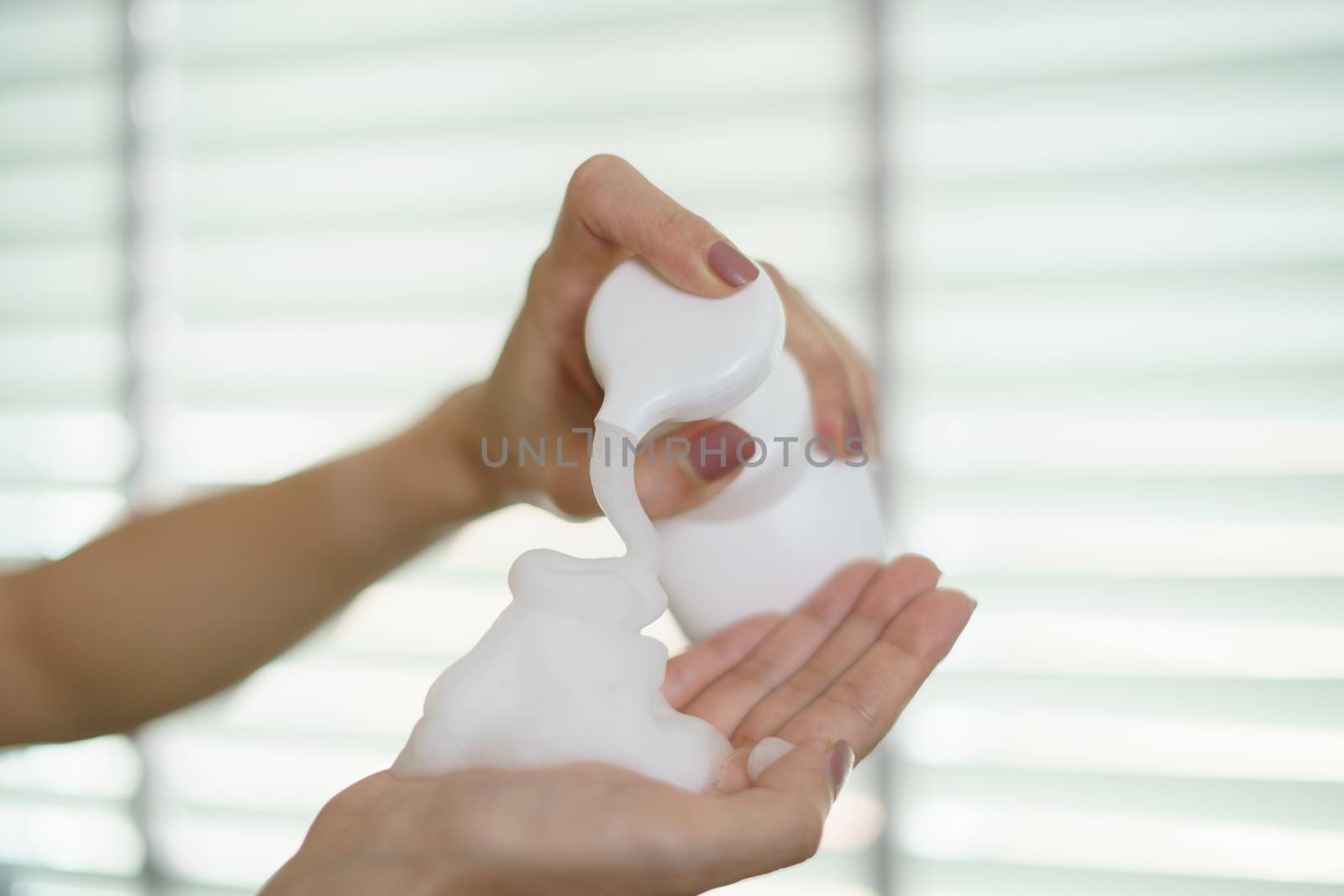 Woman hands pump liquid soap into palm for washing hands. For killing germs, bacteria and virus.