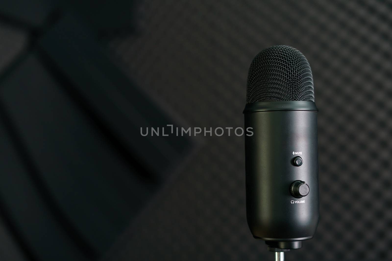 Close-up of professional condenser microphone on a black background.