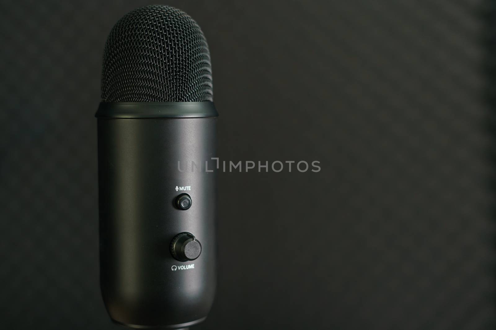 Close-up of professional condenser microphone on a black background.