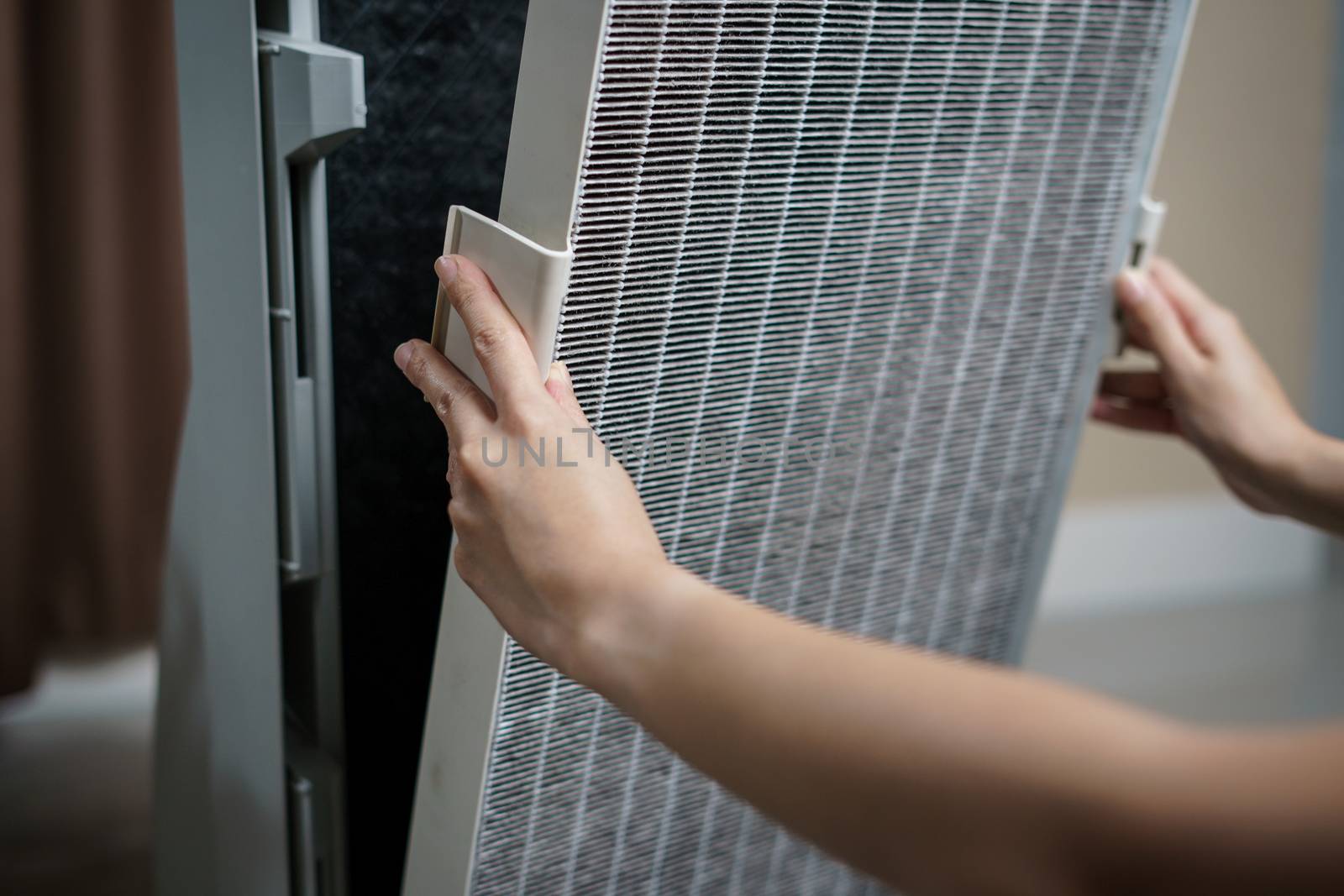 Woman hand open air purifier for clean dirty air purifier HEPA filter.