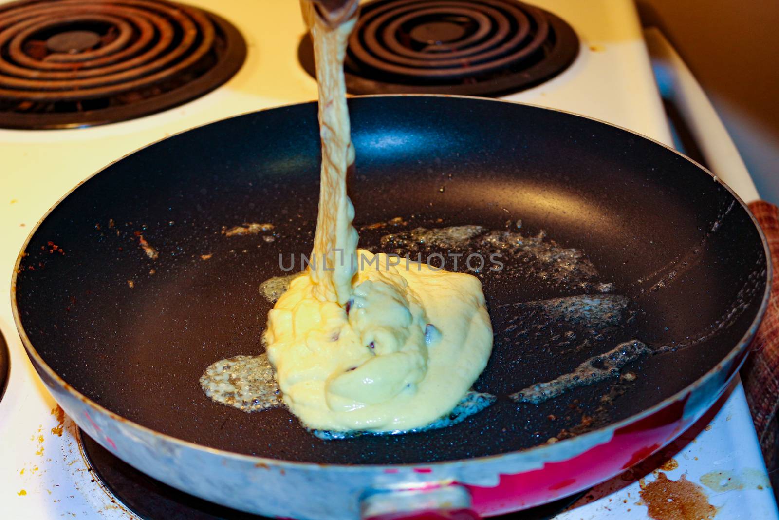 Chocolate chip pancake cooking on stove top frying pan. by mynewturtle1
