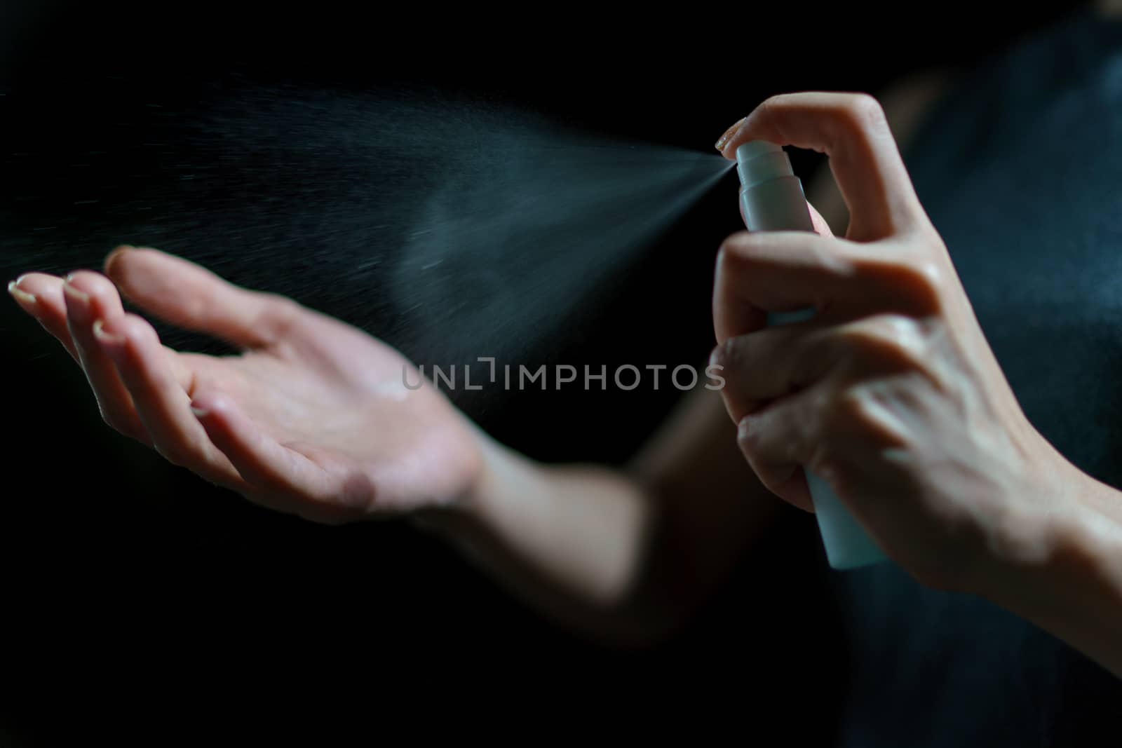 Woman hand using sanitizer spray, alcohol spraying disinfectant to stop spreading coronavirus or COVID-19.