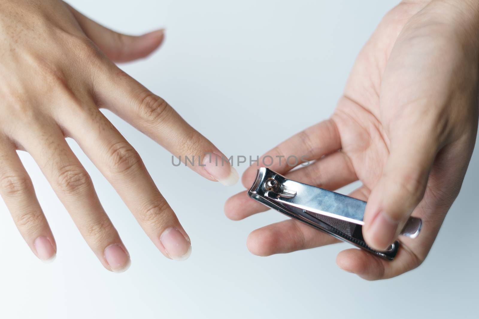 Man using nail clipper clipping her fingernails. white backgroun by sirawit99