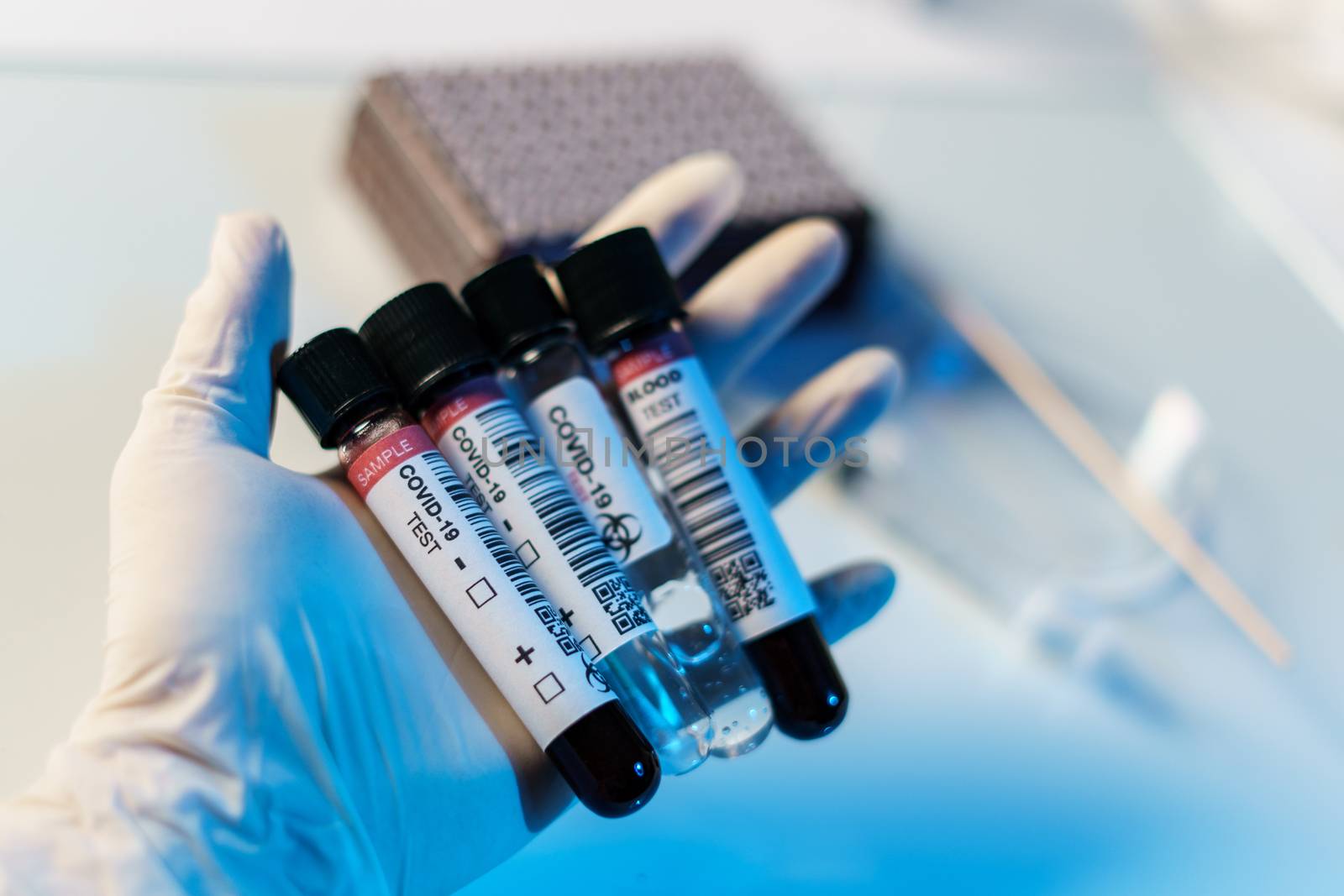 Coronavirus testing process, a hand holds tube of blood test samples and swab collection kit specimen sample testing.