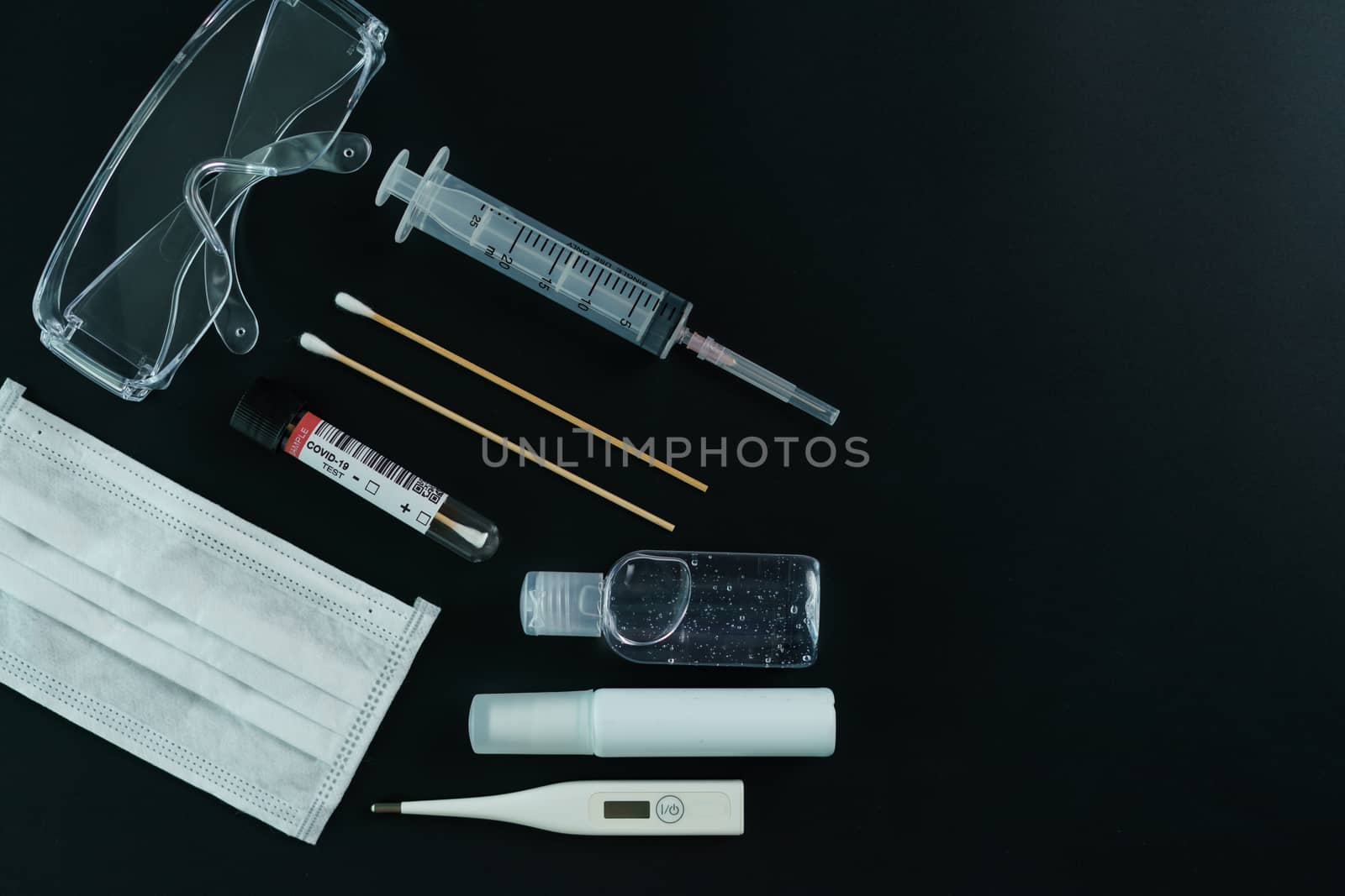 Corona virus medical equipment: Medical masks, safety glasses, syringe, cotton swab, sanitizer and thermometer with petri dish on the table. Coronavirus, Covid-19 protection.