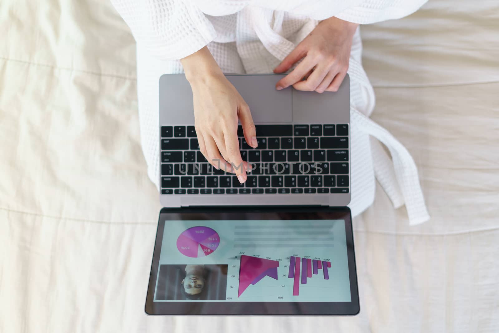 Woman work from home in quarantine during Coronavirus pandemic, woman in a bathrobe stays at home. Works in a laptop or shopping online.